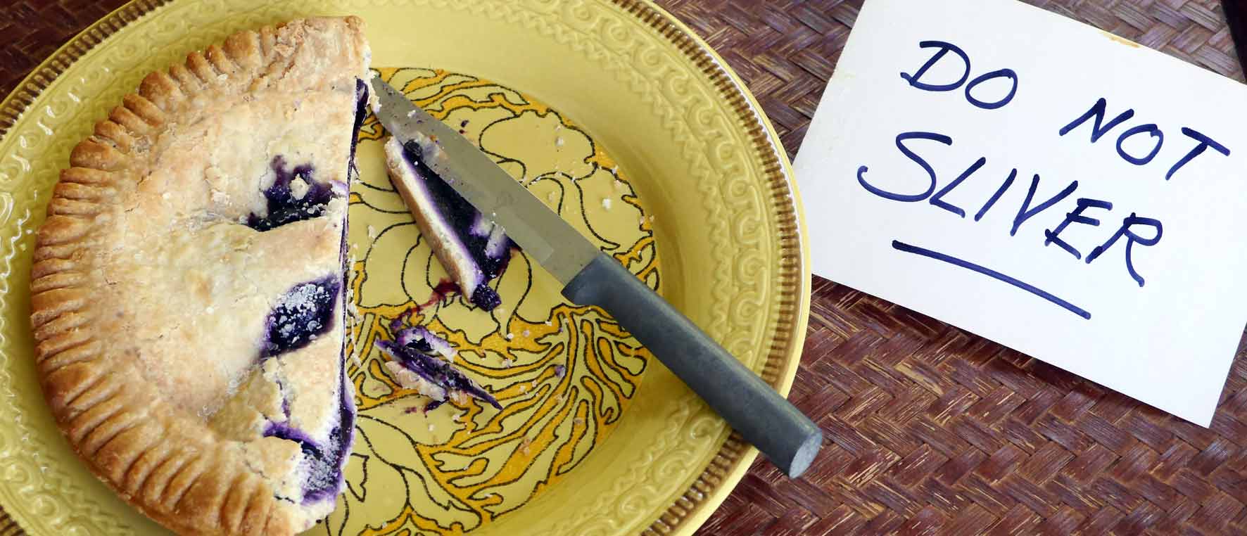 blueberry pie on yellow plate with sign saying DO NOT SLIVER
