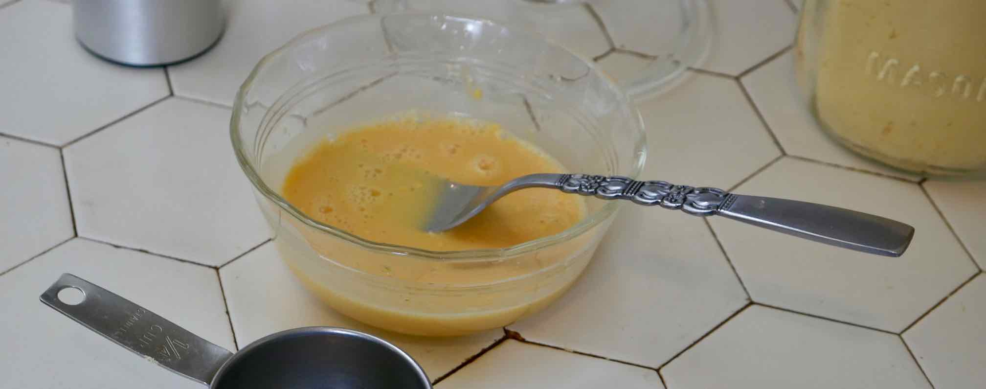 dried egg powder being mixed with water using a fork
